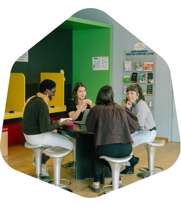 Un groupe échange autour d’une table dans l’espace d’accueil de L’Exploratoire